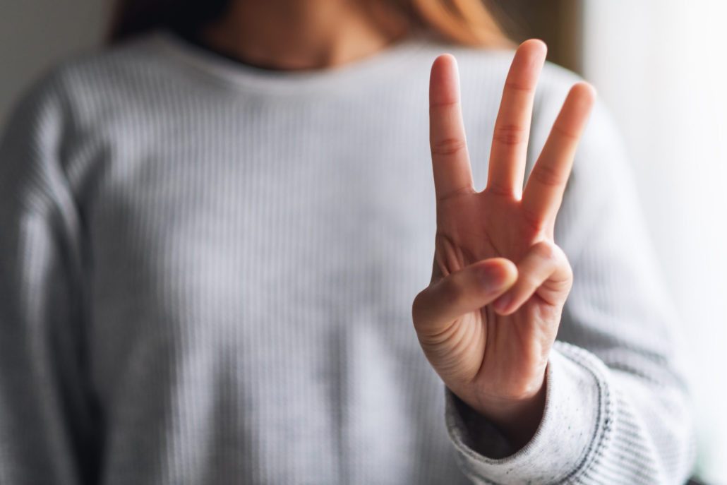 a woman making and showing number three hand sign | PAAS National